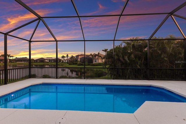 5718 Title Row Dr, Bradenton, FL 34210 - pool at dusk featuring a water view and glass enclosure