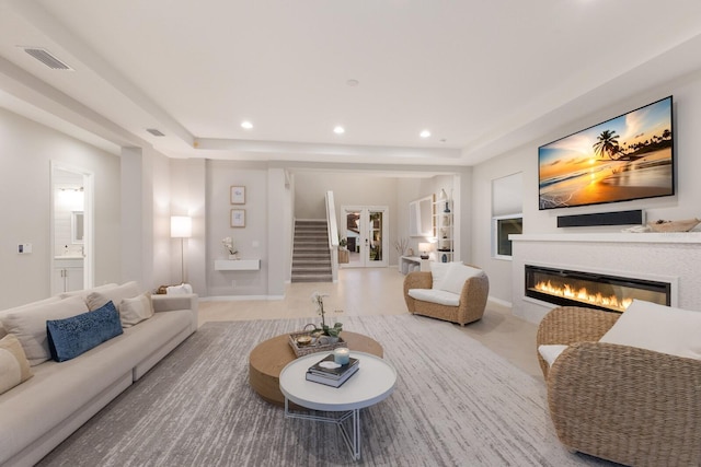 5718 Title Row Dr, Bradenton, FL 34210 - living area featuring a tray ceiling, a glass covered fireplace, stairs, and recessed lighting
