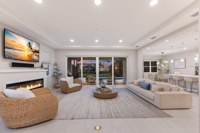 5718 Title Row Dr, Bradenton, FL 34210 - living area with a glass covered fireplace, recessed lighting, wood finished floors, and a raised ceiling