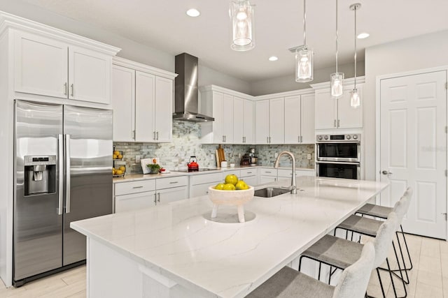 5718 Title Row Dr, Bradenton, FL 34210 - kitchen with appliances with stainless steel finishes, wall chimney range hood, white cabinets, decorative backsplash, and pendant lighting