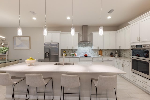 5718 Title Row Dr, Bradenton, FL 34210 - kitchen featuring wall chimney exhaust hood, stainless steel appliances, tasteful backsplash, a breakfast bar, and recessed lighting