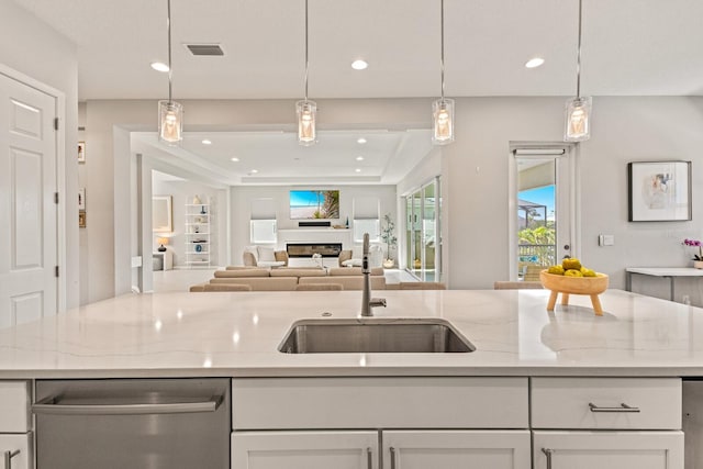 5718 Title Row Dr, Bradenton, FL 34210 - kitchen with stainless steel dishwasher, white cabinetry, light stone countertops, recessed lighting, and pendant lighting