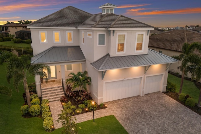 5718 Title Row Dr, Bradenton, FL 34210 - view of front of house with a standing seam roof, stucco siding, decorative driveway, and a porch