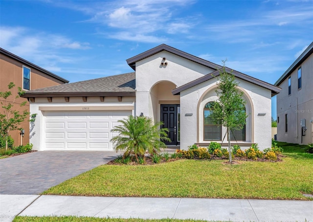 12613 Oak Hill Way, Parrish, FL 34219 - view of front of house featuring a front yard, an attached garage, driveway, and stucco siding