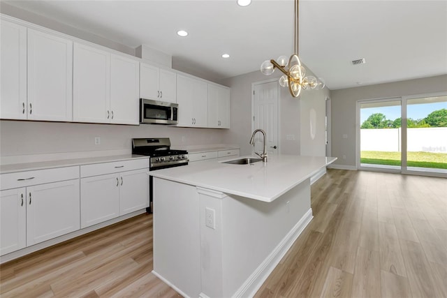 12613 Oak Hill Way, Parrish, FL 34219 - kitchen with a sink, stainless steel appliances, light wood-type flooring, white cabinets, and recessed lighting