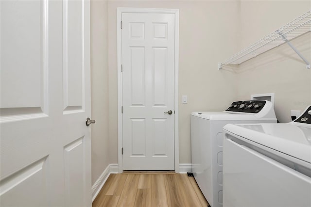 12613 Oak Hill Way, Parrish, FL 34219 - laundry room featuring separate washer and dryer, light wood-type flooring, and baseboards