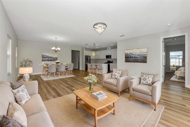 12613 Oak Hill Way, Parrish, FL 34219 - living room featuring a chandelier, light wood-style flooring, and baseboards