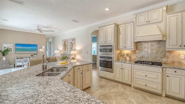 5622 Arnie Loop, Lakewood Ranch, FL 34211 - kitchen featuring cream cabinetry, a sink, stainless steel appliances, open floor plan, and premium range hood