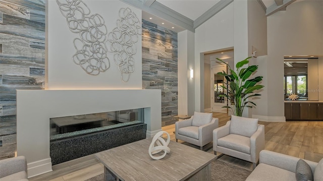 5622 Arnie Loop, Lakewood Ranch, FL 34211 - living area with a glass covered fireplace, a high ceiling, light wood-type flooring, recessed lighting, and baseboards