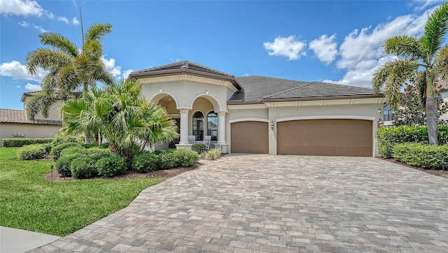 5622 Arnie Loop, Lakewood Ranch, FL 34211 - mediterranean / spanish house featuring decorative driveway, stucco siding, a garage, a tile roof, and a front lawn