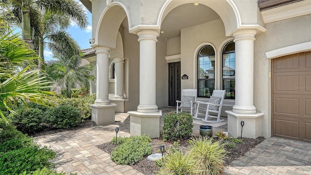 5622 Arnie Loop, Lakewood Ranch, FL 34211 - doorway to property with covered porch, stucco siding, and a garage