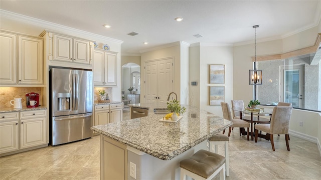 5622 Arnie Loop, Lakewood Ranch, FL 34211 - kitchen featuring stainless steel appliances, cream cabinets, arched walkways, a sink, and ornamental molding