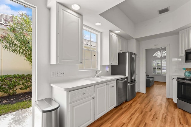 7716 Uliva Way, Sarasota, FL 34238 - kitchen featuring stainless steel appliances, a sink, light countertops, white cabinetry, and recessed lighting