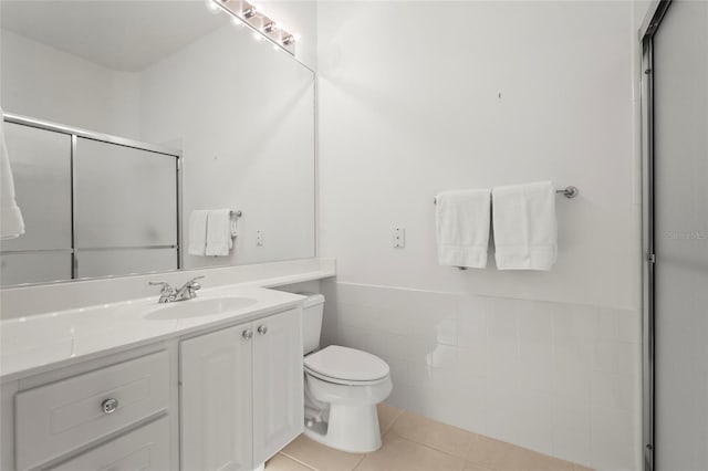 7716 Uliva Way, Sarasota, FL 34238 - bathroom featuring toilet, vanity, an enclosed shower, tile patterned flooring, and wainscoting