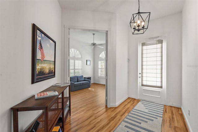 7716 Uliva Way, Sarasota, FL 34238 - foyer featuring light wood-style floors, a chandelier, baseboards, and ceiling fan