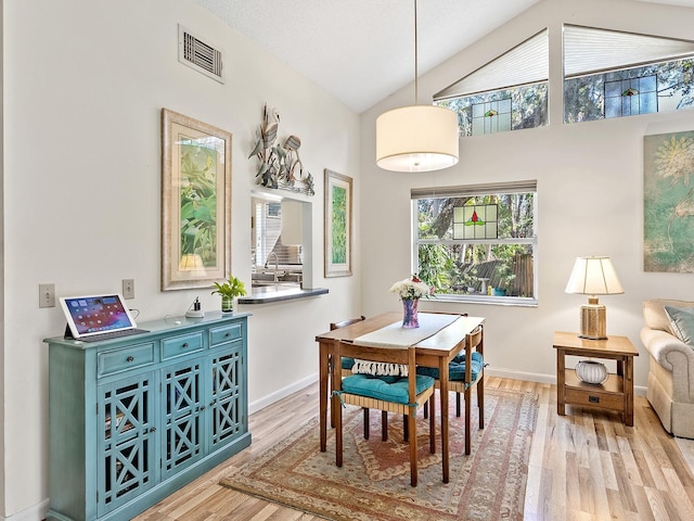 4869 Village Gardens Dr Unit 189, Sarasota, FL 34234 - dining space with light wood-type flooring and vaulted ceiling