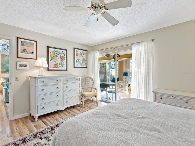 4869 Village Gardens Dr Unit 189, Sarasota, FL 34234 - bedroom with access to exterior, light wood-type flooring, a textured ceiling, and ceiling fan