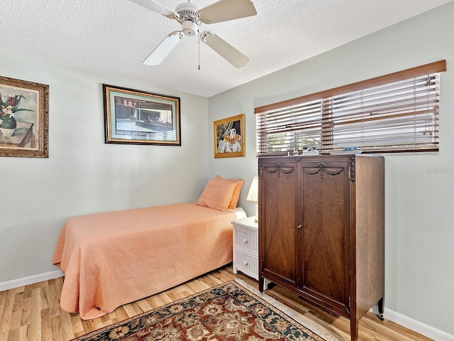 4869 Village Gardens Dr Unit 189, Sarasota, FL 34234 - bedroom featuring light wood-style floors, a ceiling fan, and a textured ceiling