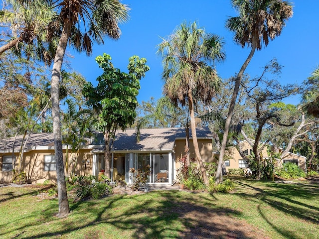4869 Village Gardens Dr Unit 189, Sarasota, FL 34234 - view of front of house with a front lawn, a sunroom, and a shingled roof