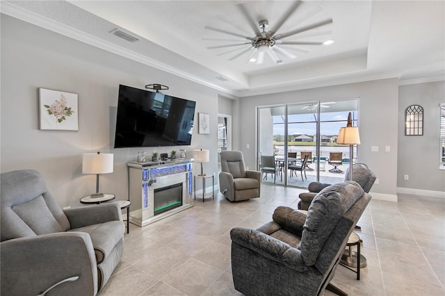 4406 Rustling Pines Ter, Parrish, FL 34219 - living room featuring a tray ceiling, baseboards, light tile patterned flooring, crown molding, and a ceiling fan