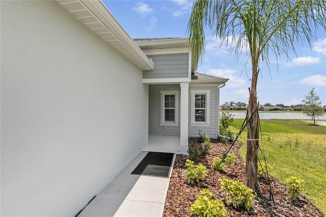 4406 Rustling Pines Ter, Parrish, FL 34219 - view of exterior entry with a water view, a yard, and stucco siding