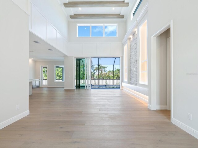 430 Pheasant Way, Sarasota, FL 34236 - unfurnished living room with beamed ceiling, light wood-style flooring, and a high ceiling