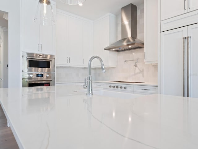 430 Pheasant Way, Sarasota, FL 34236 - kitchen featuring wall chimney exhaust hood, stainless steel double oven, white cabinets, and decorative backsplash