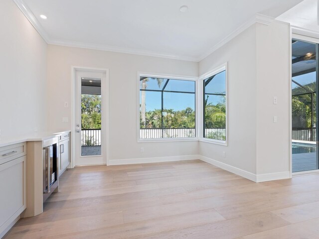 430 Pheasant Way, Sarasota, FL 34236 - unfurnished living room with plenty of natural light, light wood finished floors, crown molding, recessed lighting, and beverage cooler