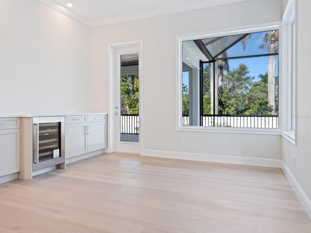 430 Pheasant Way, Sarasota, FL 34236 - unfurnished room featuring wine cooler, light wood-style floors, plenty of natural light, and ornamental molding