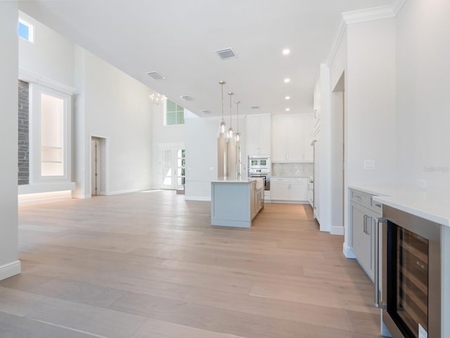 430 Pheasant Way, Sarasota, FL 34236 - kitchen featuring wine cooler, stainless steel oven, open floor plan, pendant lighting, and a center island with sink