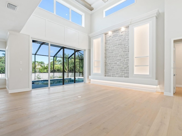 430 Pheasant Way, Sarasota, FL 34236 - spare room featuring a sunroom, light wood-type flooring, healthy amount of natural light, and a towering ceiling