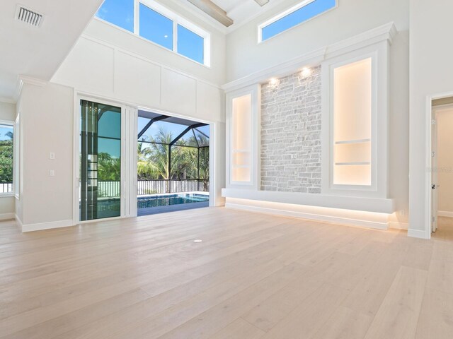 430 Pheasant Way, Sarasota, FL 34236 - spare room featuring ornamental molding, plenty of natural light, wood finished floors, and a towering ceiling
