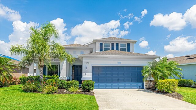 7379 47th Avenue Cir E, Bradenton, FL 34203 - view of front of property with an attached garage, driveway, a front lawn, and stucco siding