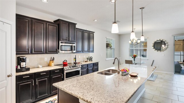 7379 47th Avenue Cir E, Bradenton, FL 34203 - kitchen featuring a sink, stainless steel appliances, tasteful backsplash, light stone counters, and a chandelier