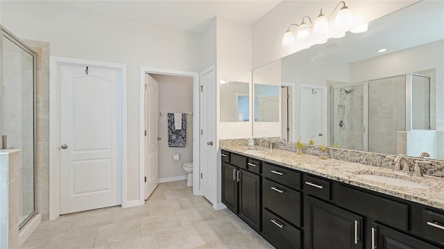 7379 47th Avenue Cir E, Bradenton, FL 34203 - full bathroom featuring a shower stall, toilet, double vanity, tile patterned floors, and baseboards