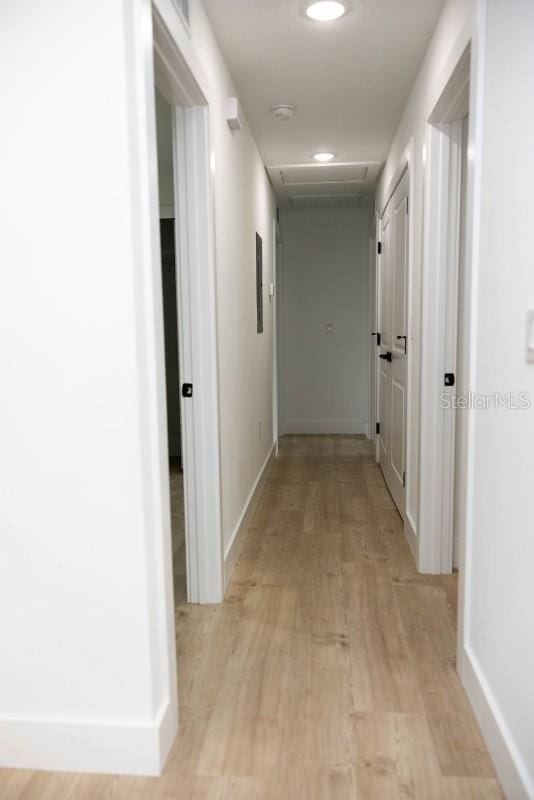 hall with light wood finished floors, baseboards, attic access, and recessed lighting