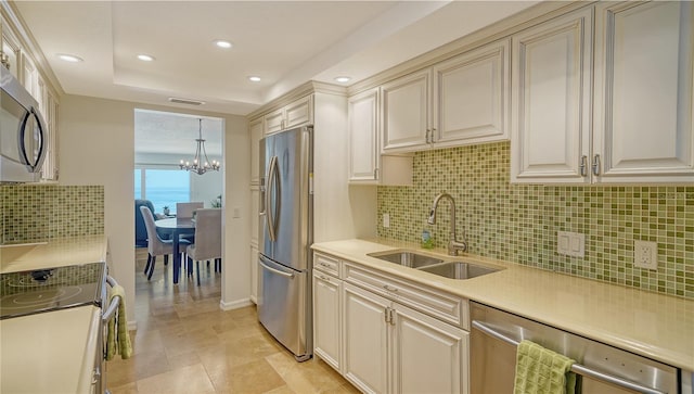 19 Whispering Sands Dr Unit 805, Sarasota, FL 34242 - kitchen with stainless steel appliances, a sink, tasteful backsplash, recessed lighting, and a chandelier