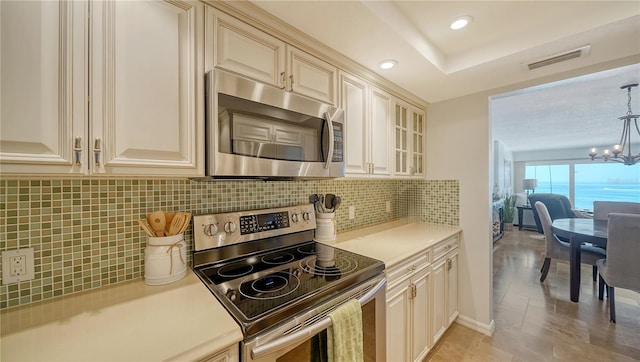 19 Whispering Sands Dr Unit 805, Sarasota, FL 34242 - kitchen with appliances with stainless steel finishes, cream cabinets, light countertops, a chandelier, and recessed lighting