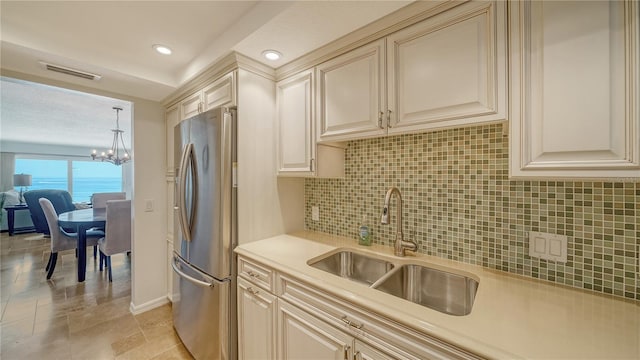 19 Whispering Sands Dr Unit 805, Sarasota, FL 34242 - kitchen with freestanding refrigerator, a sink, a chandelier, backsplash, and light countertops