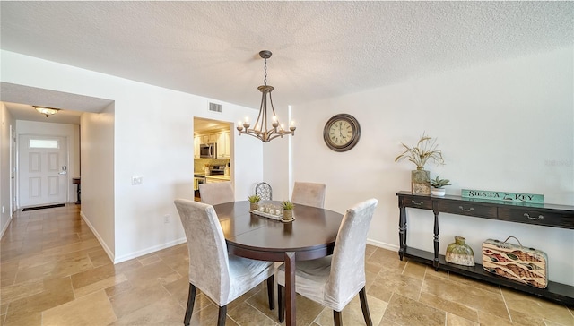19 Whispering Sands Dr Unit 805, Sarasota, FL 34242 - dining room featuring a chandelier, stone tile flooring, baseboards, and a textured ceiling