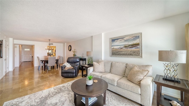 19 Whispering Sands Dr Unit 805, Sarasota, FL 34242 - living room featuring light stone finish floors, a chandelier, and a textured ceiling