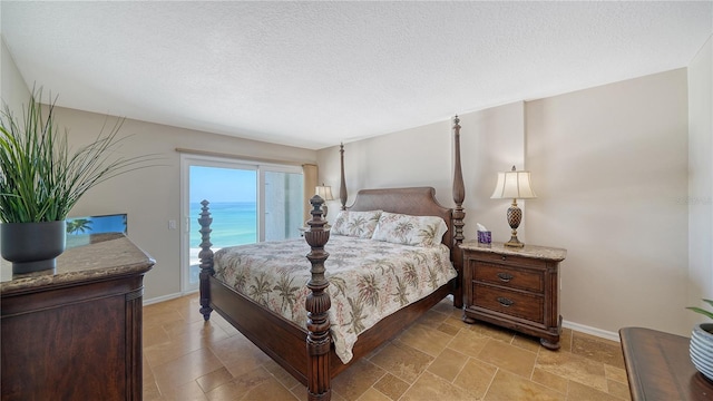 19 Whispering Sands Dr Unit 805, Sarasota, FL 34242 - bedroom featuring access to outside, a textured ceiling, and baseboards
