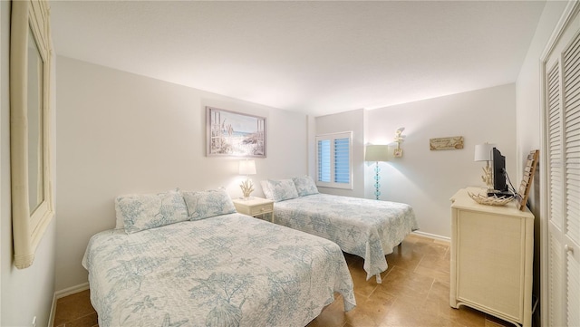 19 Whispering Sands Dr Unit 805, Sarasota, FL 34242 - bedroom featuring baseboards, a closet, and light tile patterned floors
