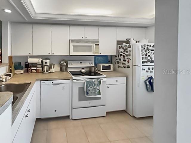 8977 Midnight Pass Rd Unit 521, Sarasota, FL 34242 - kitchen with white appliances, white cabinets, light tile patterned floors, light countertops, and a sink