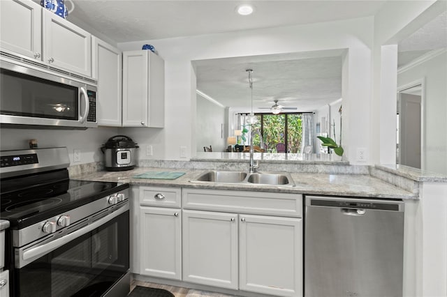 157 Pinehurst Dr Unit 157, Bradenton, FL 34210 - kitchen featuring stainless steel appliances, a sink, ceiling fan, ornamental molding, and white cabinets