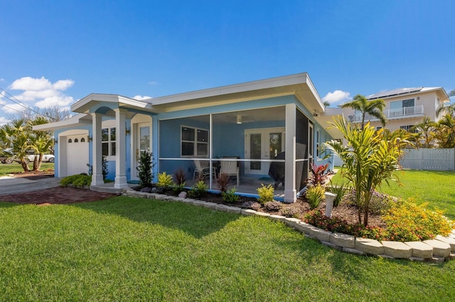 view of front of home featuring a garage, a sunroom, and driveway