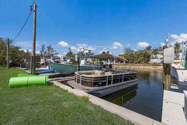 dock area featuring boat lift, a water view, and a yard