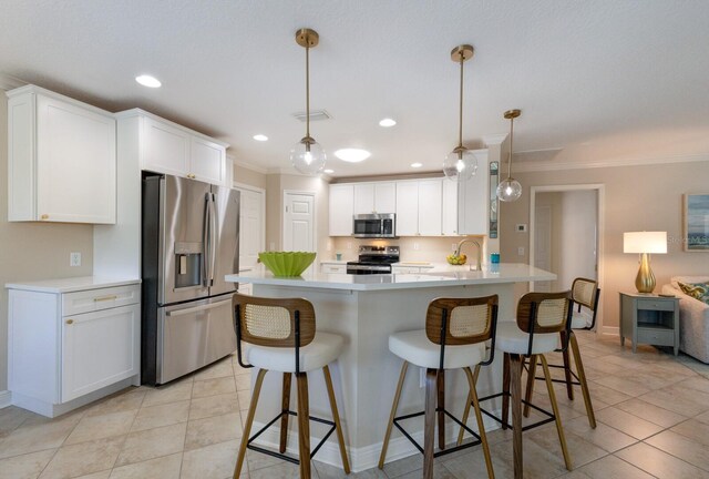 kitchen with stainless steel appliances, ornamental molding, light tile patterned floors, light countertops, and a kitchen bar