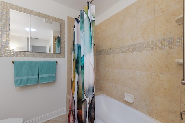 bathroom with shower / tub combo with curtain, toilet, and baseboards