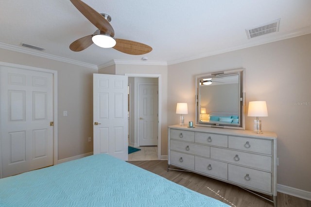 bedroom with crown molding, wood finished floors, baseboards, and a ceiling fan